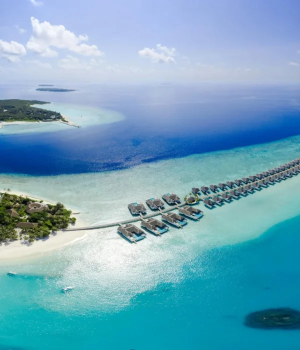 Serene view of Sun Siyam Olhuveli beach in the Maldives, showcasing pristine white sands, crystal-clear waters, and tropical surroundings, ideal for couples enjoying a romantic 4N/5D honeymoon getaway.