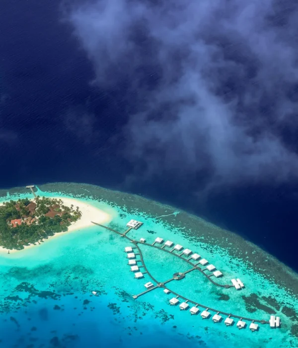 Aerial view of an overwater villa at Sun Siyam Olhuveli in the Maldives, surrounded by turquoise waters and pristine beaches, perfect for couples enjoying a 4N/5D romantic honeymoon filled with luxury, relaxation, and ocean adventures.