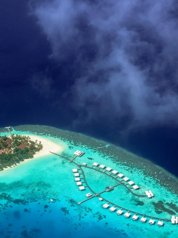 Aerial view of an overwater villa at Sun Siyam Olhuveli in the Maldives, surrounded by turquoise waters and pristine beaches, perfect for couples enjoying a 4N/5D romantic honeymoon filled with luxury, relaxation, and ocean adventures.