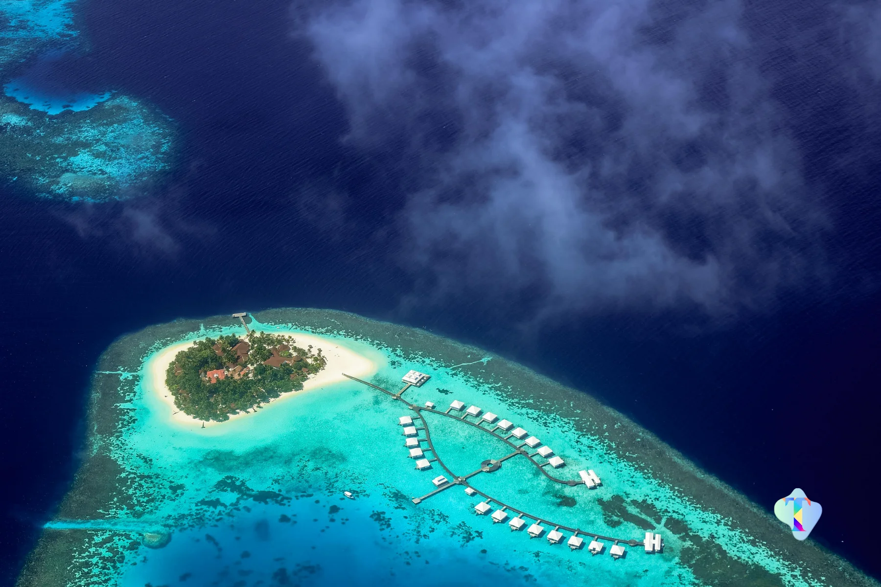Aerial view of an overwater villa at Sun Siyam Olhuveli in the Maldives, surrounded by turquoise waters and pristine beaches, perfect for couples enjoying a 4N/5D romantic honeymoon filled with luxury, relaxation, and ocean adventures.